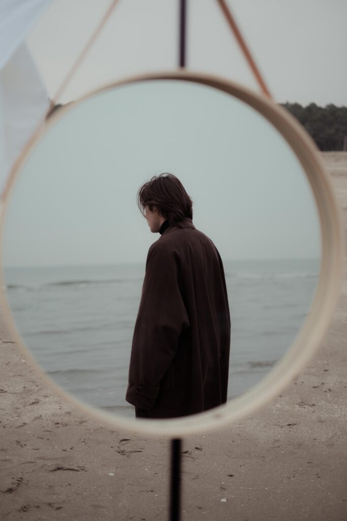 reflection of yourself in the mirror. thinking on the beach
